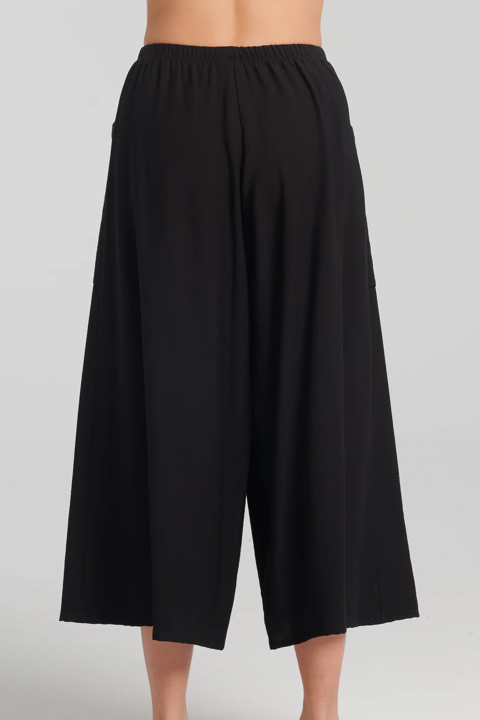 Ishtar Pants by Kollontai, Black, back view, cropped, very wide legs, elastic waist, patch pockets, lightweight rayon knit, sizes XS to XXL, made in Montreal