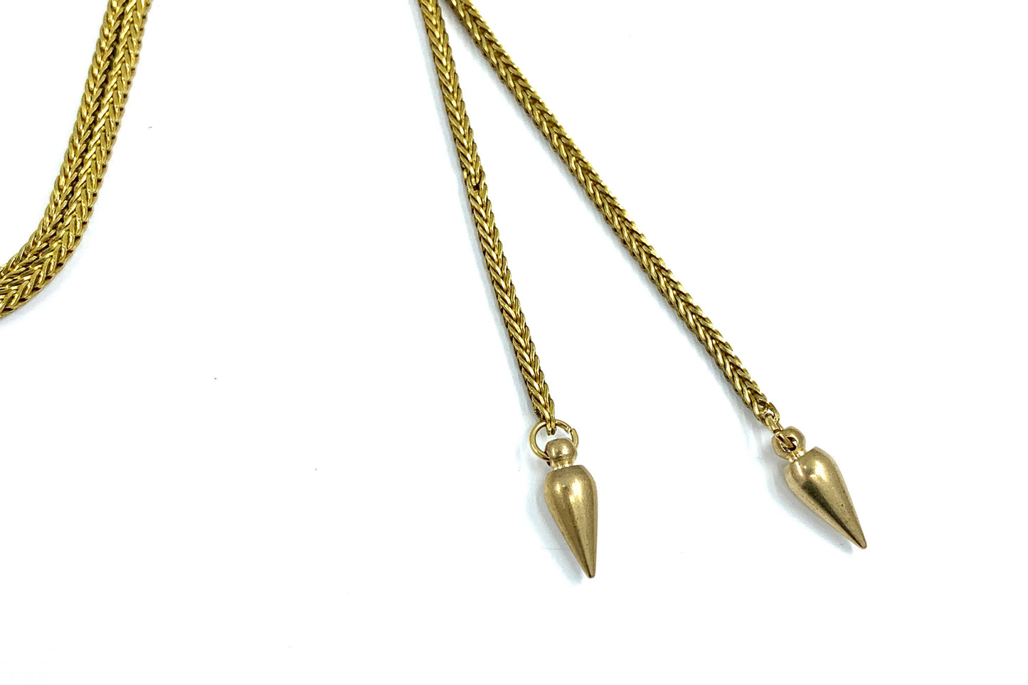 A close up detail of the ends of the SHOOTING GUNS Triangle Bolo Tie necklace from Lord Violet is shown against a white background.