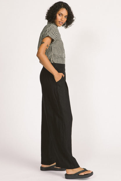 Romy Pants by Allison Wonderland, Black, side view, wide legs, full length, flat waistband with elastic at the side, pleats, pockets, eco-fabric, linen, sizes 2-12, made in Vancouver