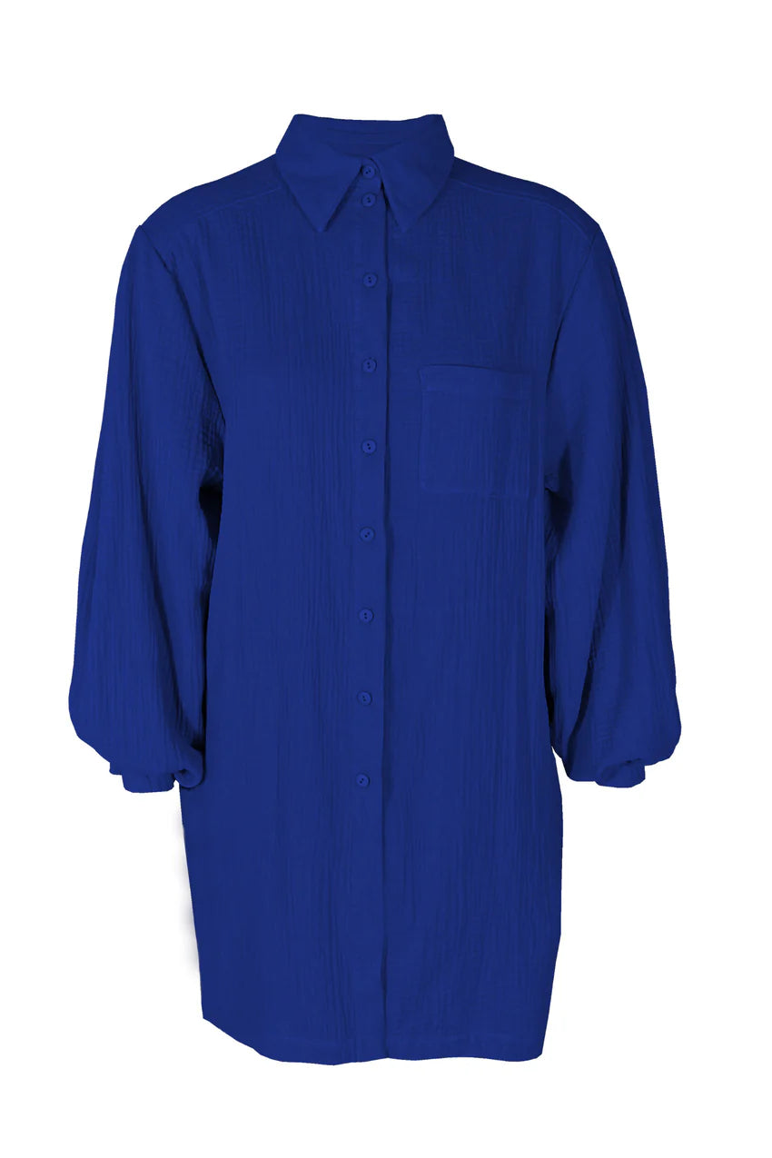 The Kronos Tunic by Melow in Colbalt, with a blouse collar, button front, an above-the-knee length and long sleeves that puff and gather at the wrists, is shown in front of a white background.