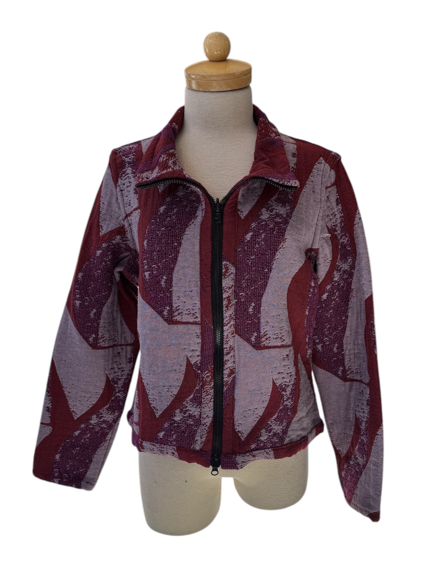 The Reversible Short Bomber Jacket by Véronique d’Aragon in purple, a cropped jacket with a classic collar and a zip front that's reversible inside out, is show on a mannequin against a white background.