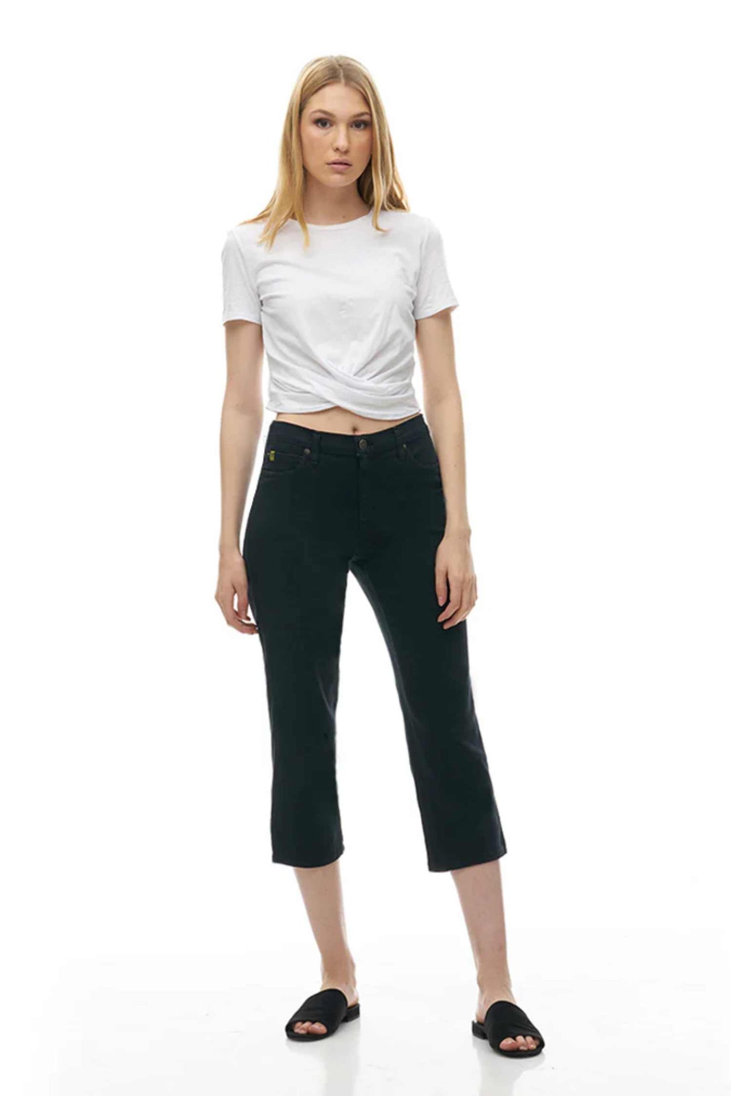 Woman wearing the CHLOE Classic Rise Straight Leg Capri Yoga Jeans in Black standing in front of a white background