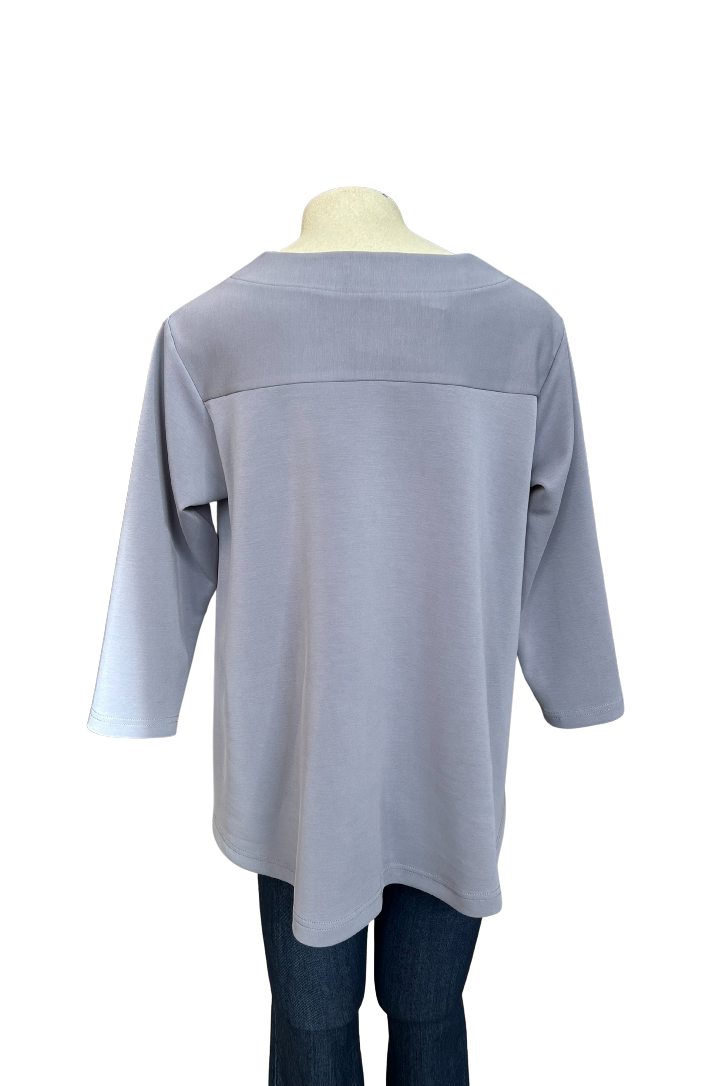 A back view of the Vanessa Top by Solomia in Blue is shown on a mannequin against a white background. It has a notched neckline, 3/4 sleeves, a rounded hi-low hemline, and a vertical seam down the front. 
