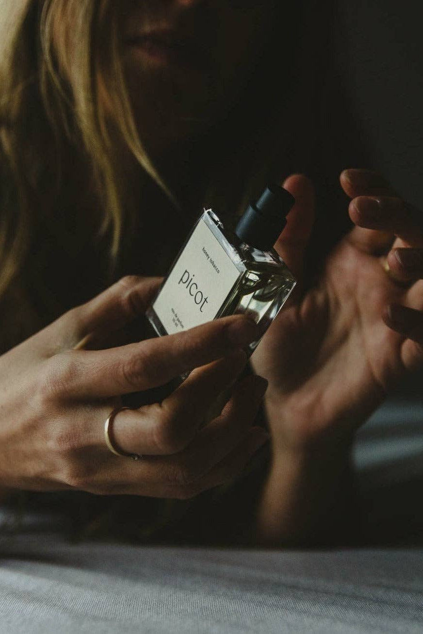 Person holding a small bottle of Picot Honey Tobacco eau de parfum