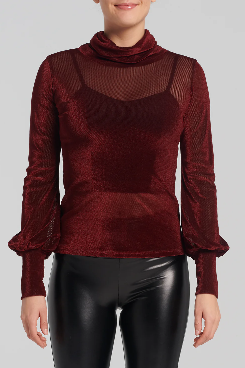 Woman wearing the Lavenza Top by Kollontai in Bordeaux with faux leather pants