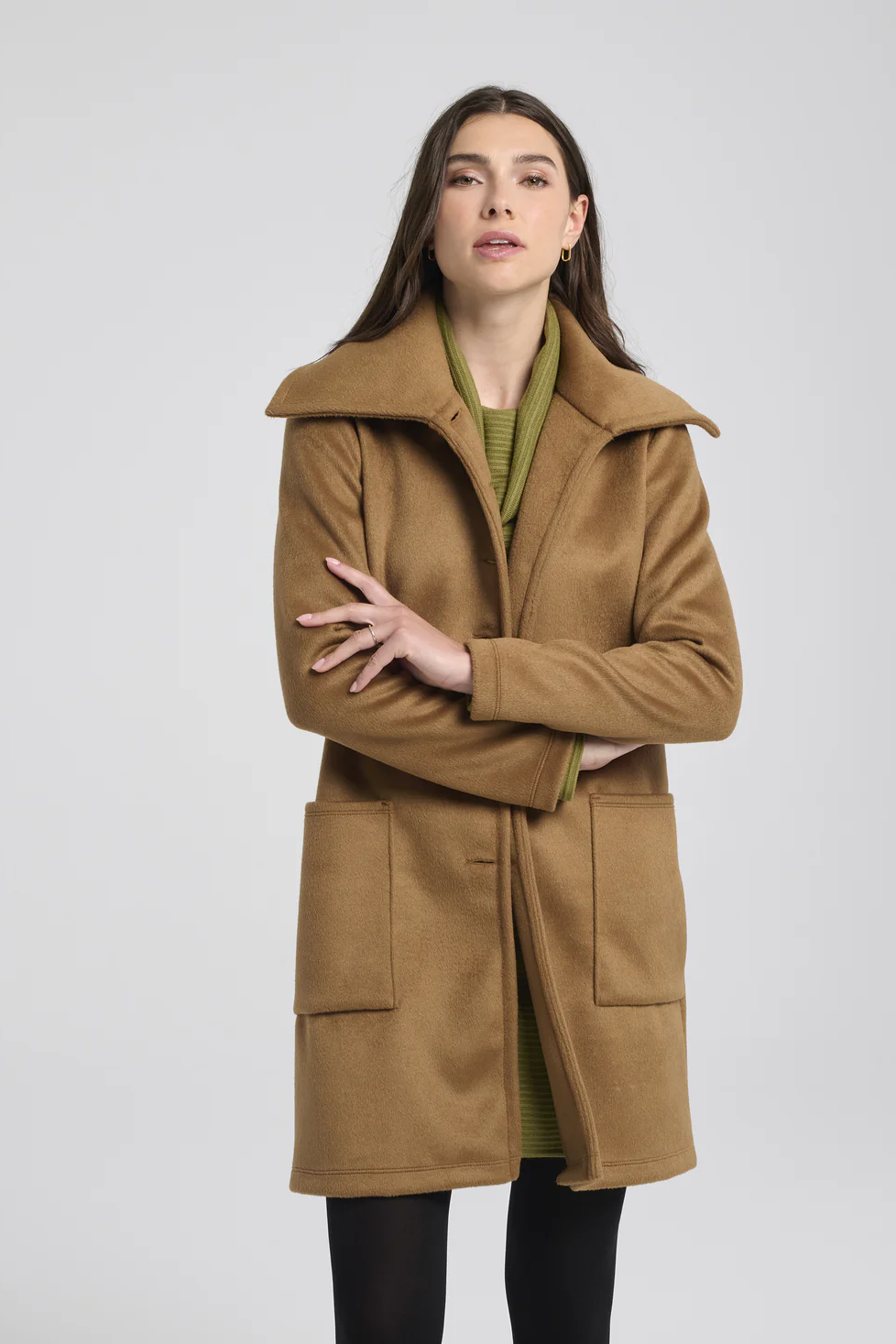 3/4 view of a woman wearing the Russ Jacket by Kollontai in Caramel, standing in front of a white background 