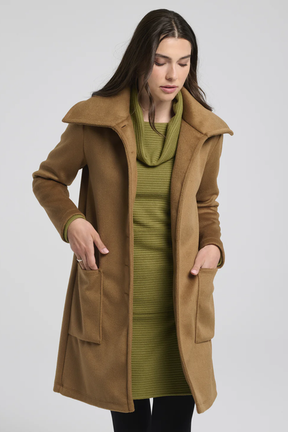 3/4 view of a woman wearing the Russ Jacket by Kollontai in Caramel, standing in front of a white background 