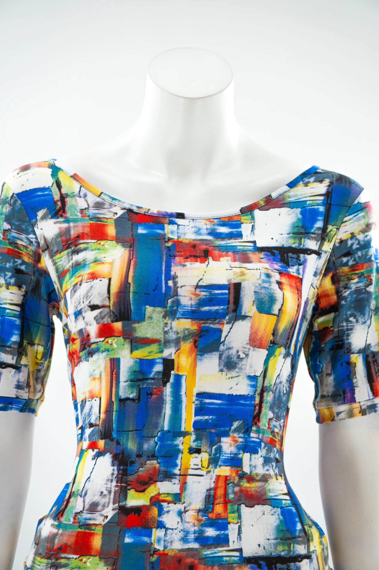 A close up view of the Colori T-Shirt by Karkass in Multicolour, featuring an abstract brushstroke pattern, wideneck, and mid-length sleeves, is shown 
on a mannequin in front of a white background. 