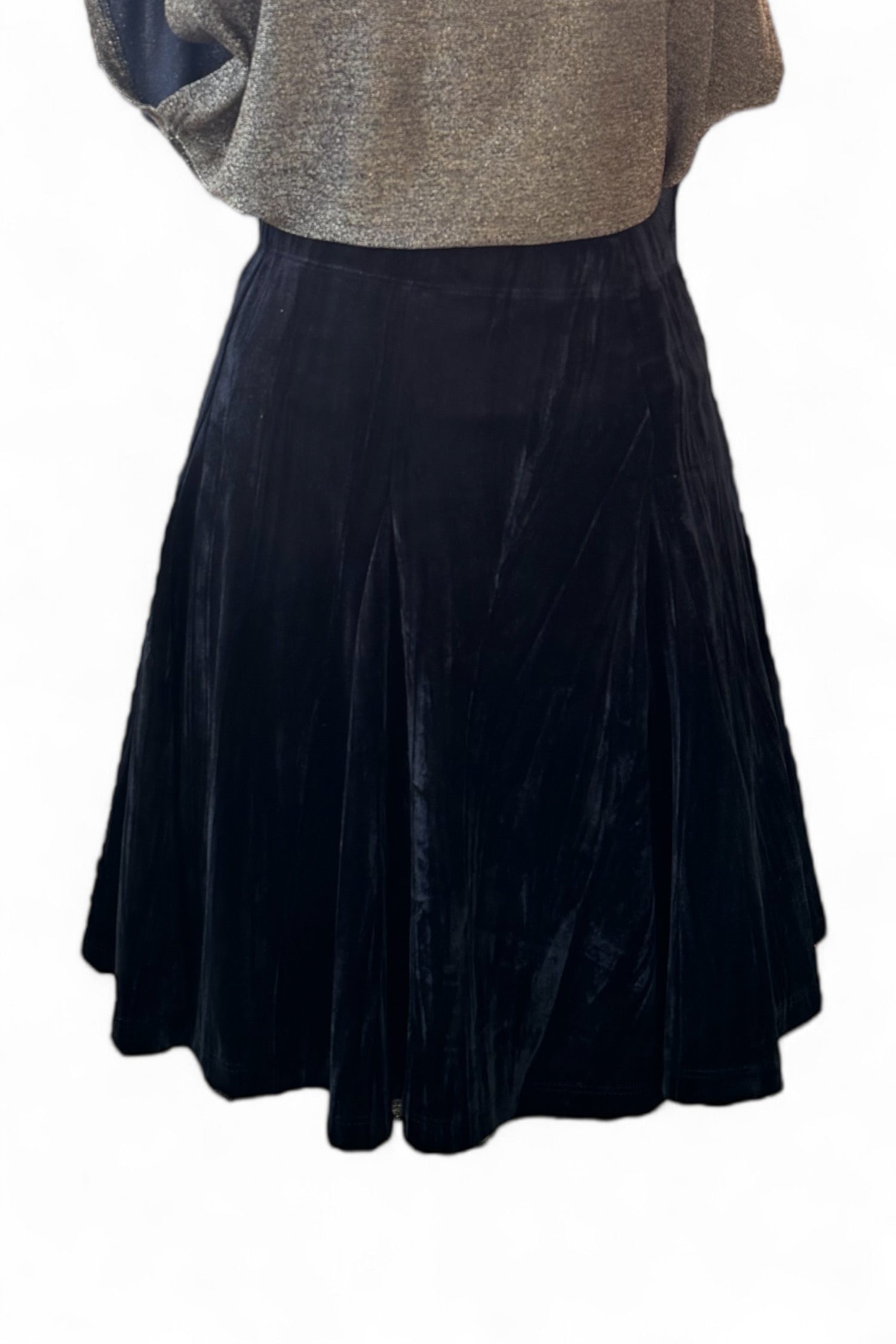 The Lustra Skirt by Luc Fontaine in Black, an A-line crushed velvet skirt with an elastic waistband and an above the knee length, is shown a mannequin in front of a white background. 