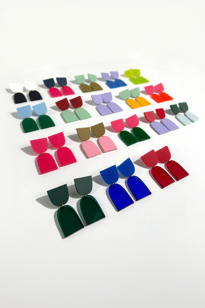 Colorful earrings displayed in rows on a white background