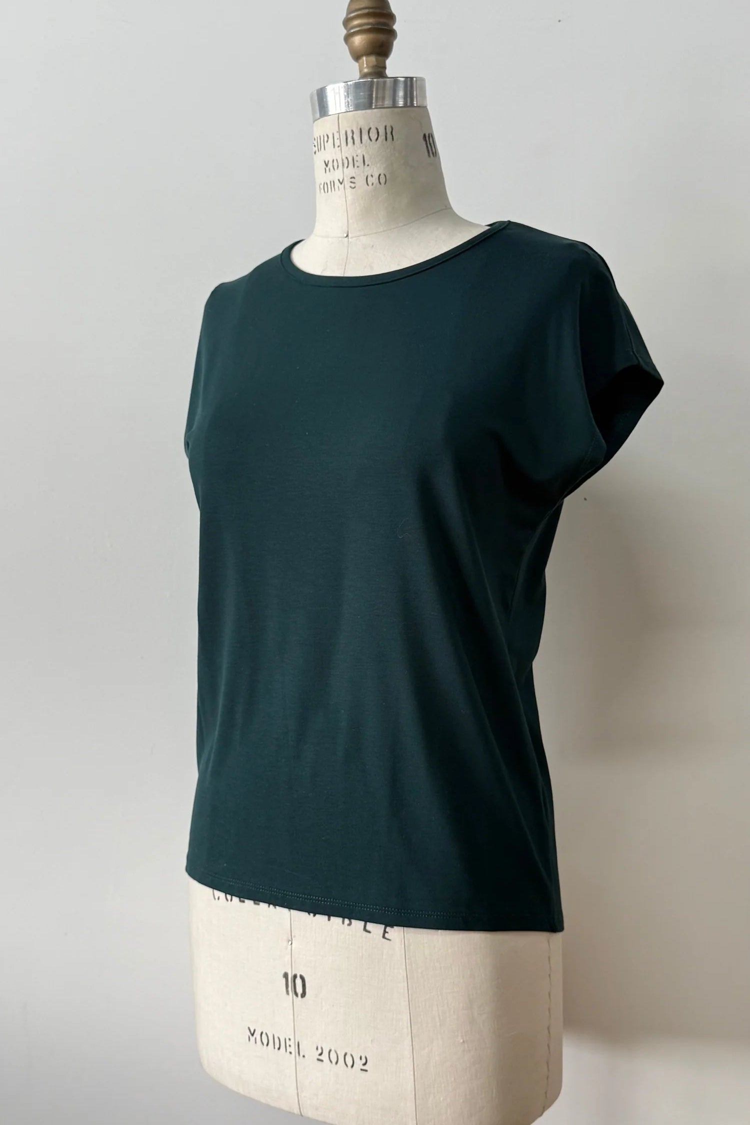 The Eowyn T-Shirt by Kollontai in Green is shown on a white mannequin against a white 