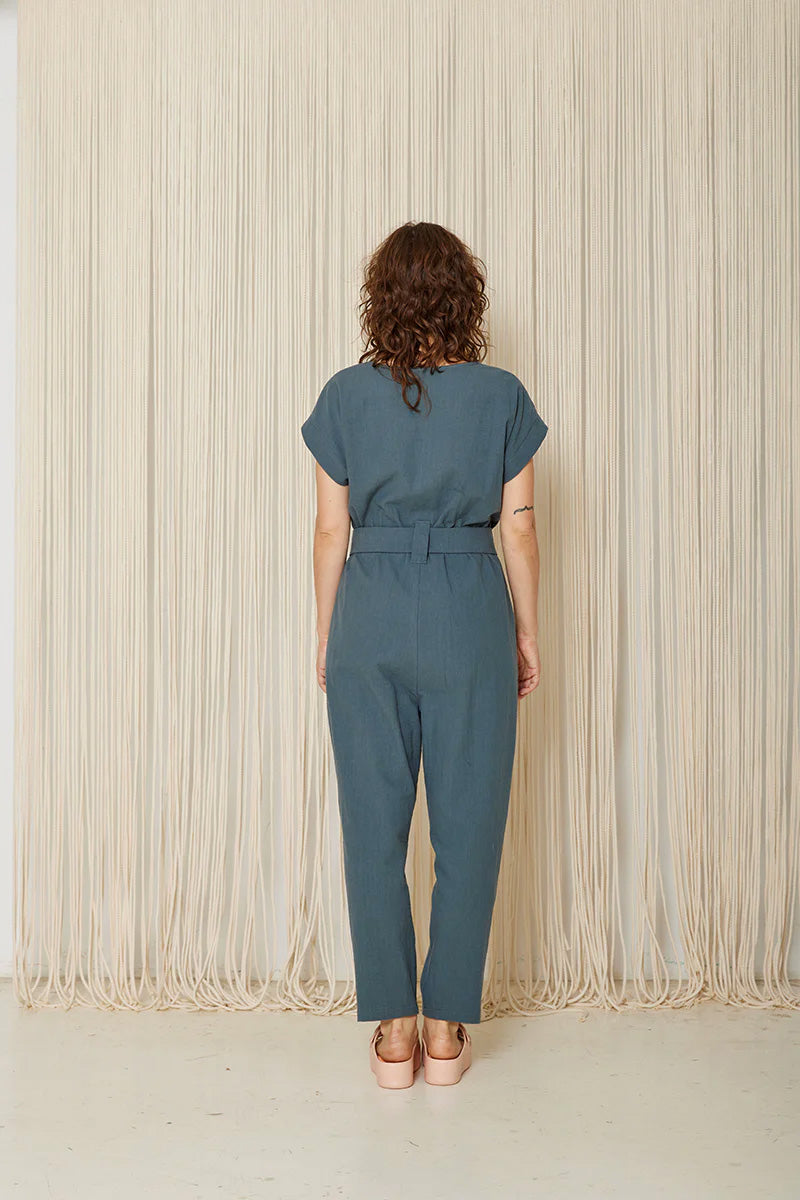 Arnica Jumpsuit by Cokluch, Steel, back view, short extended sleeves, round neck, front button placket, loop-buckle belt at waist, ankle-length, eco-fabric, cotton, sizes XS to XL, made in Montreal 
