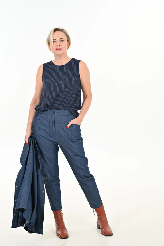 Front view of a woman wearing the Alice Cocoon Pants by Julei Design in Denim with a dark top, standing in front of a white background 