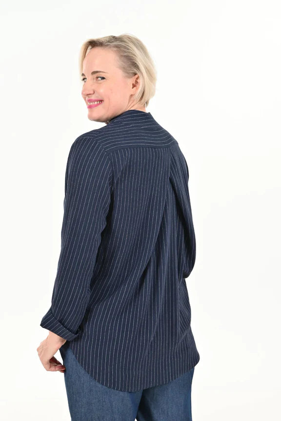 Back view of a woman wearing the Charlie Top by Julei Design in Navy Stripe with the Alice Cocoon Pant in Denim, standing in front of a white background