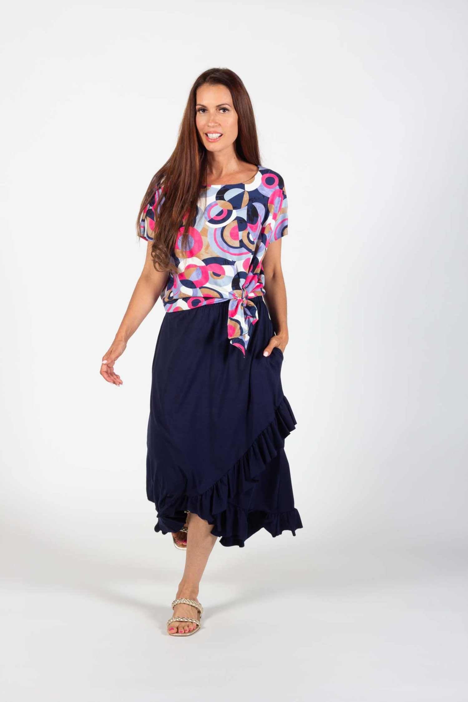 A woman wearing the Cameron Top and Catrina Skirt in Navy by Pure Essence standing in front of a white background