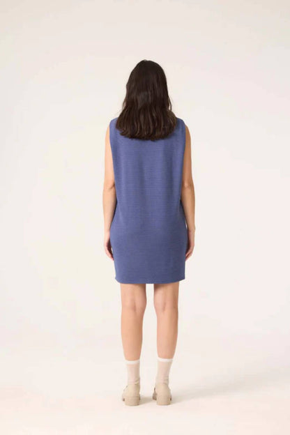 Back view of a woman wearing the Galaxy Dress by Cokluch in Horizon blue, standing in front of a white background 