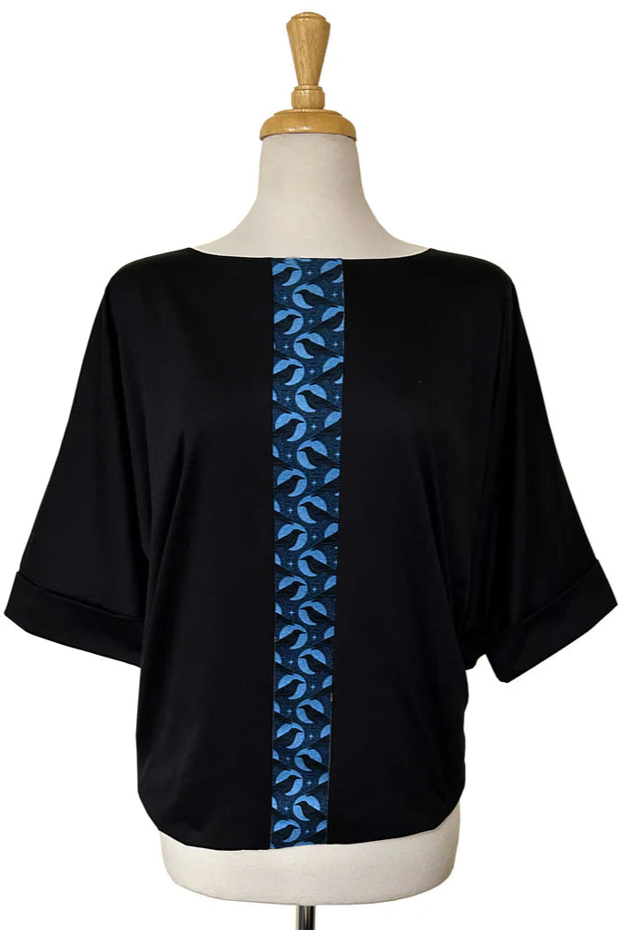 The Batwing Top by Desserts and Skirts is shown on a mannequin against a white background. It's a Black batwing top with a strip of Raven fabric down the front, a boatneck, and 3/4 foldable cuffs. 
