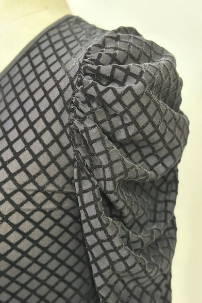 Close up detail of the black cut velvet diamond pattern on the Octavia Sweater by Kollontai, shown on a mannequin. 