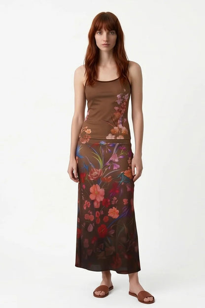 A woman wearing the Morganne Top by Kollontai, a brown floral tank top with spaghetti straps. She is wearing it the matching Charlotte Skirt against a white background