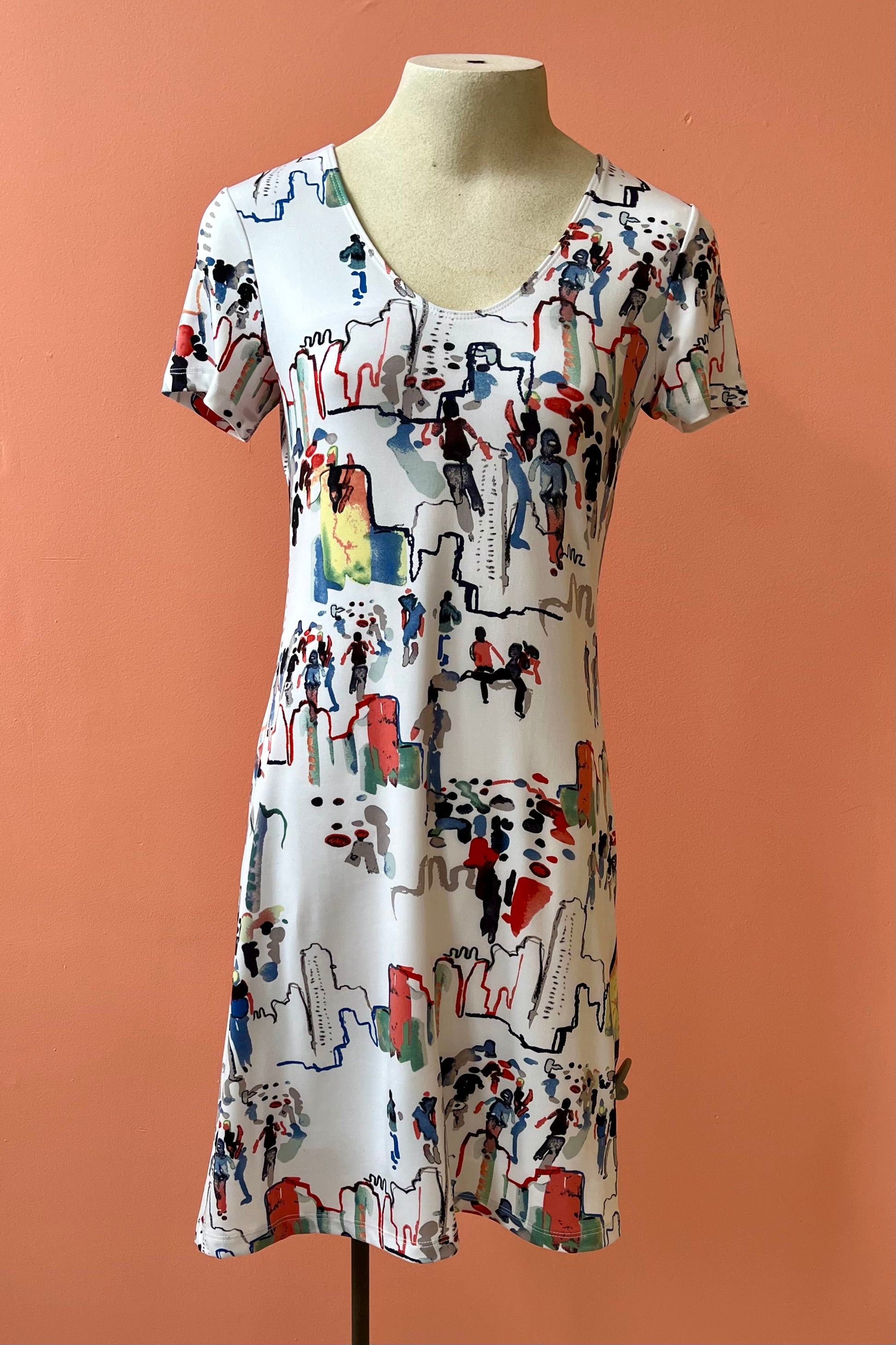 United Dress by Yul Voy, watercolour city-scape print on white background, v-neck, short sleeves, fit and flare shape, above the knee, sizes XS to XXL, made in Montreal 
