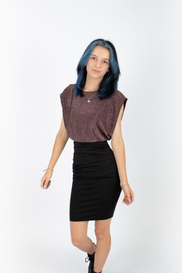 A woman wearing the Saki Top by Infime in glitter Pink with a black skirt, standing in front of a white background 