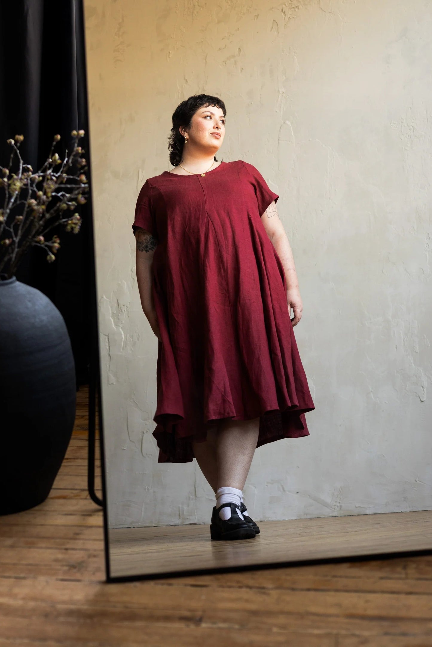 A woman wearing the Astoria Dress by Lights of All in Garnet