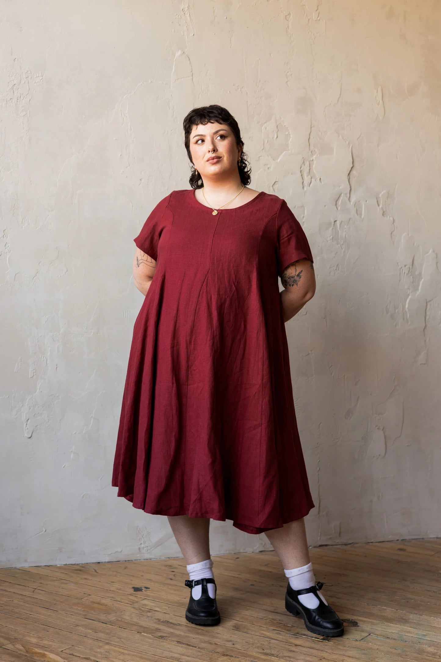 A woman wearing the Astoria Dress by Lights of All in Garnet