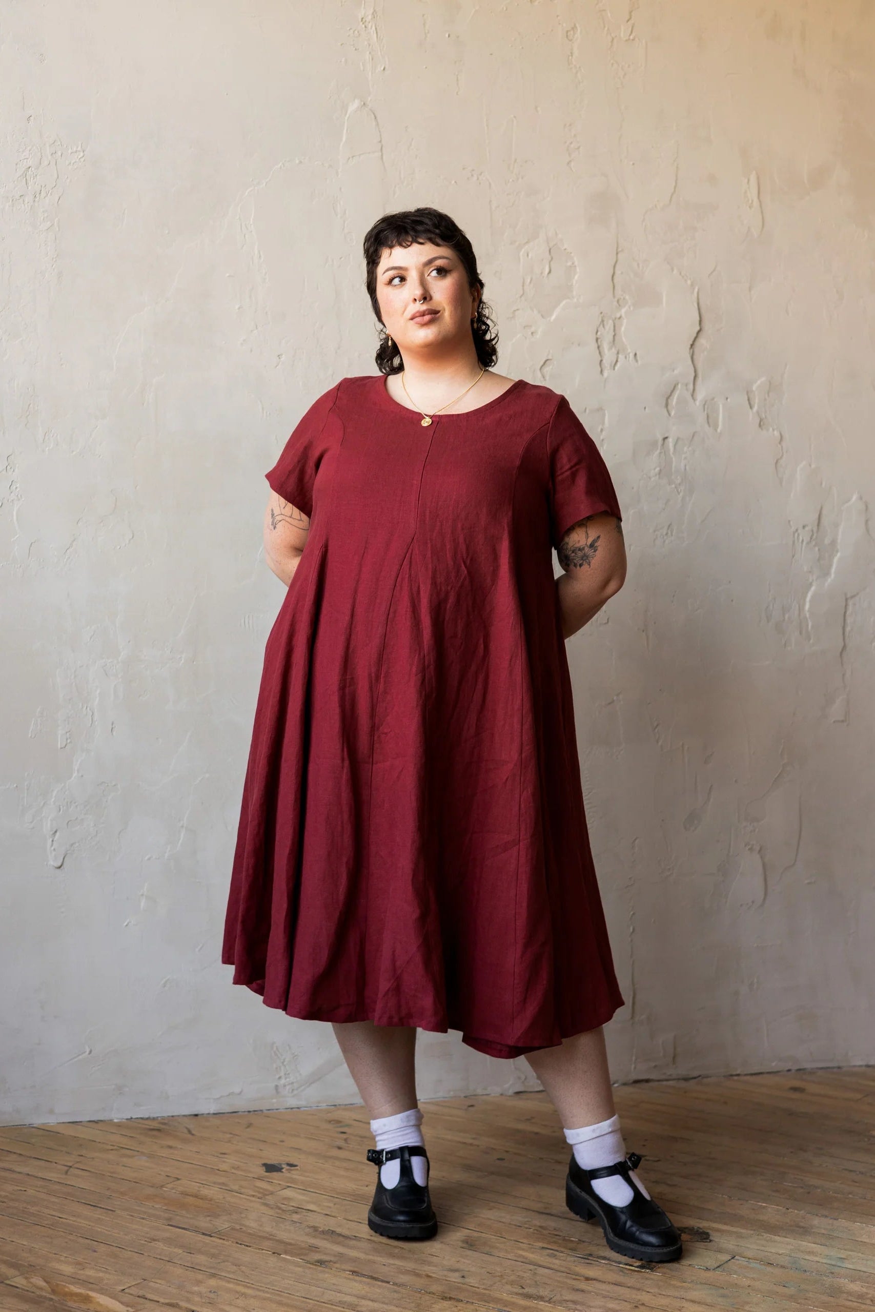 A woman wearing the Astoria Dress by Lights of All in Garnet
