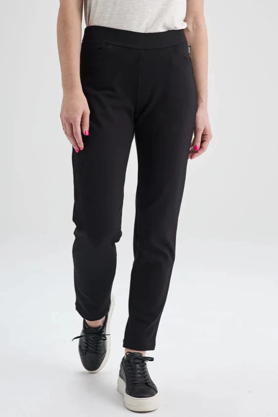 Waist-down view of the Sherbrooke Pants by Message Factory in Black, pull-on semi-fitted pants with side pockets made from Lenzing Ecovero viscose. She is standing in front of a white background. 