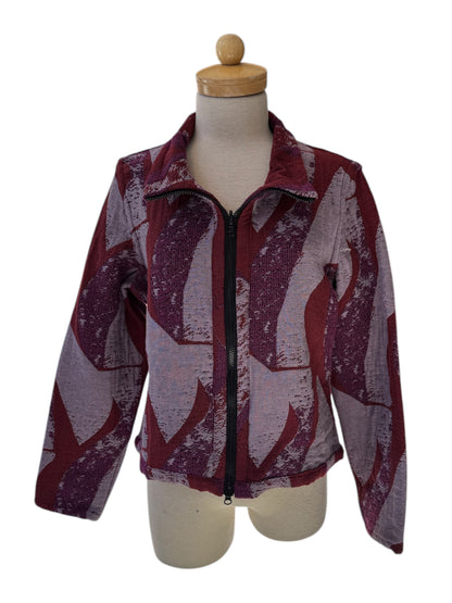 The Reversible Short Bomber Jacket by Véronique d’Aragon in purple, a cropped jacket with a classic collar and a zip front that's reversible inside out, is show on a mannequin against a white background. 