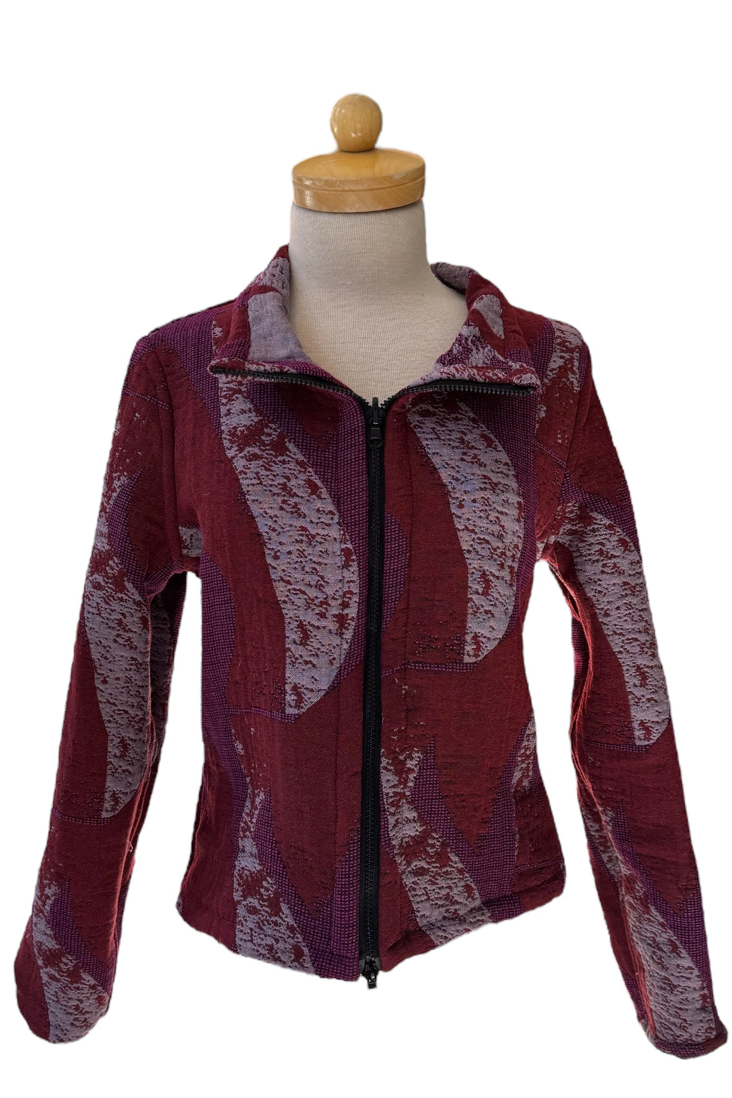 The Reversible Short Bomber Jacket by Véronique d’Aragon in purple, a cropped jacket with a classic collar and a zip front that's reversible inside out, is show on a mannequin against a white background. 