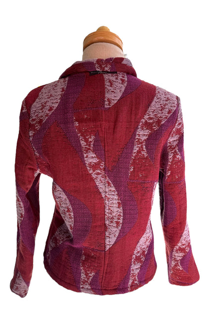 A back view of the Reversible Short Bomber Jacket by Véronique d’Aragon in purple, a cropped jacket with a classic collar and a zip front that's reversible inside out, is show on a mannequin against a white background. 