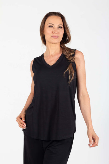 A woman wearing the Charlotte Camisole by Pure Essence in Black, standing in front of a white background,