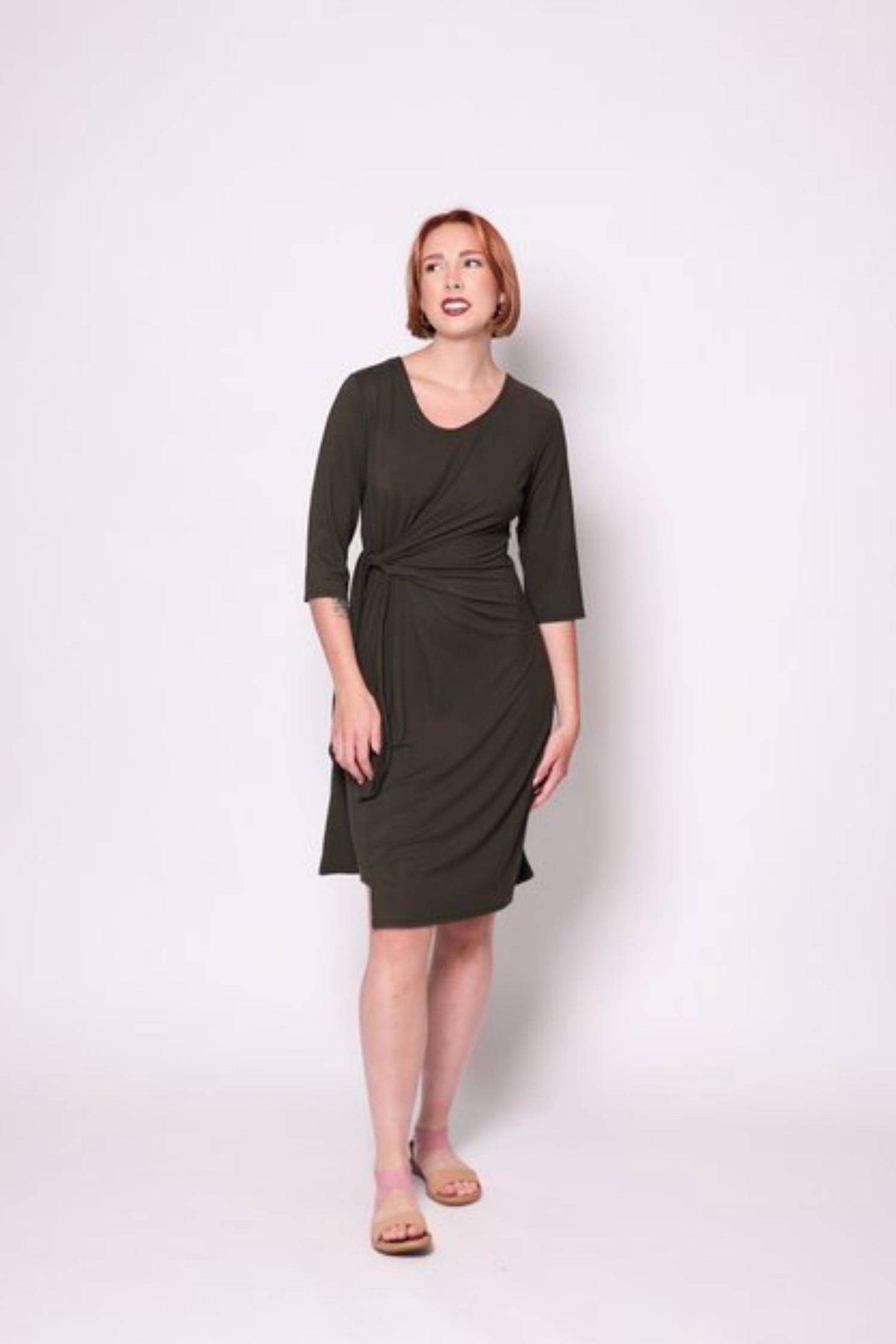 A woman wearing the Mariela Dress by Tangente in Spruce, standing in front of a white background 