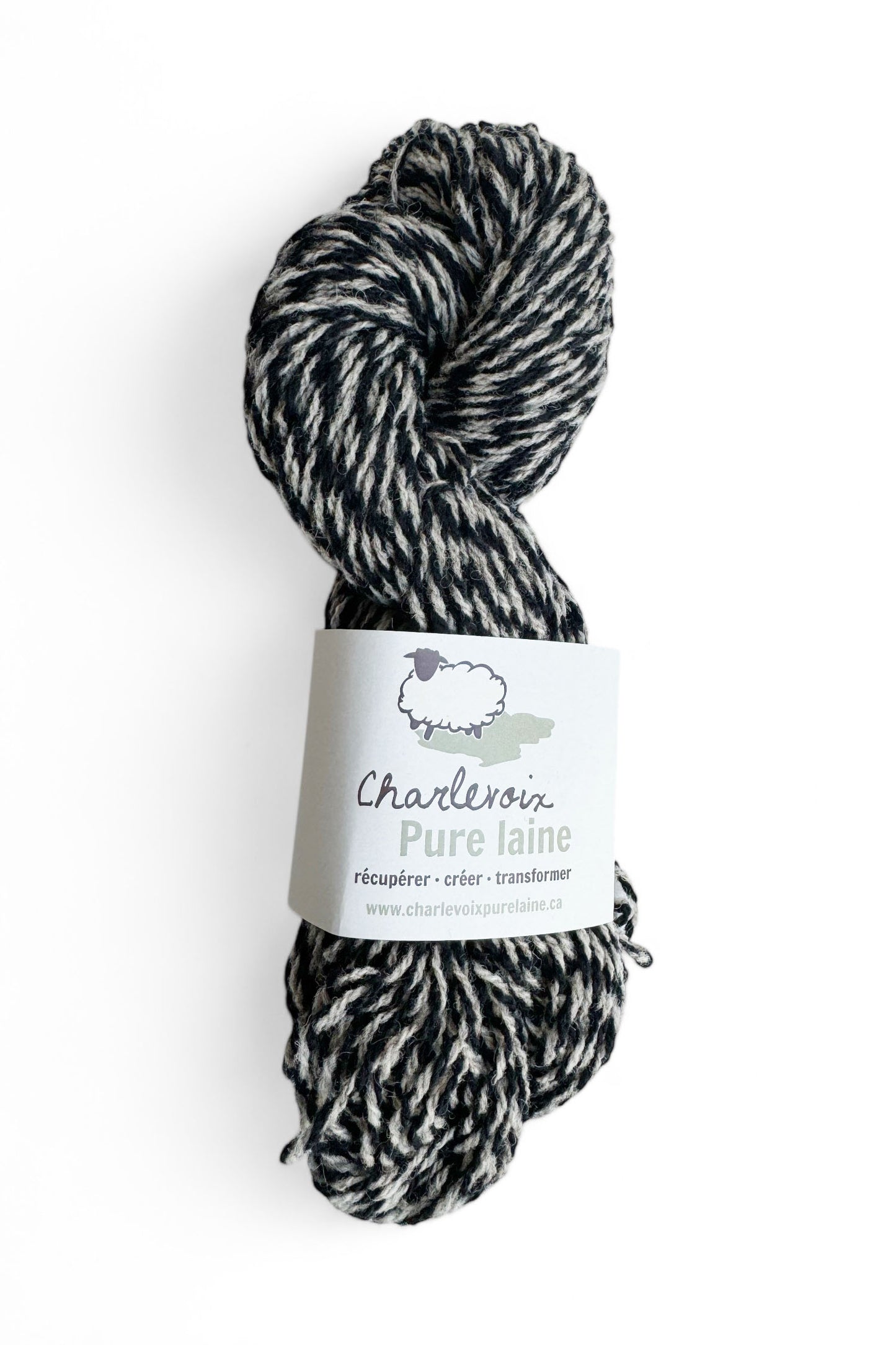 A skein of Grey and Black yarn from Charlevoix Pure Laine is shown against a white background 