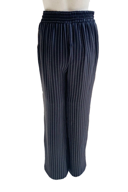 A baci view of the Cheyenne Pants by Pure Essence in Black pinstripe is shown on a mannequin in front of a white background 