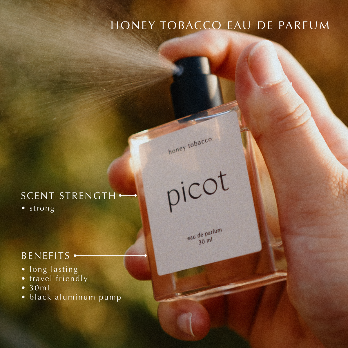 Hand holding a Picot honey tobacco eau de parfum bottle with product details on a blurred natural background