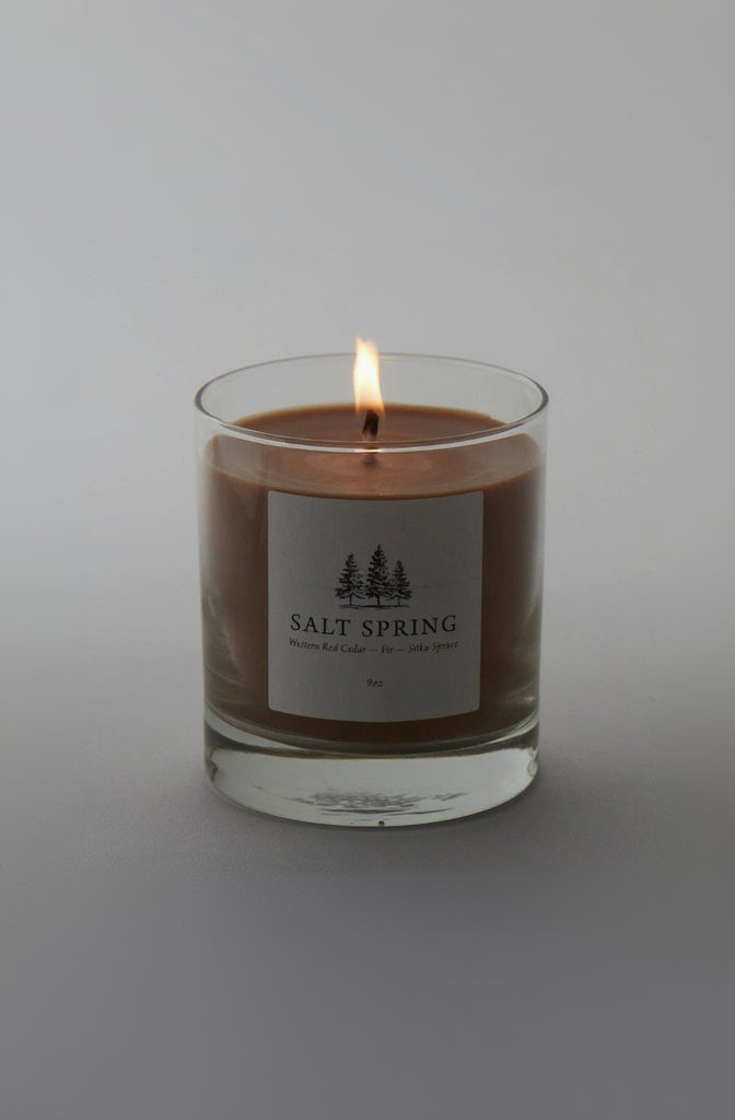 Candle in a glass jar with a label on a gray background