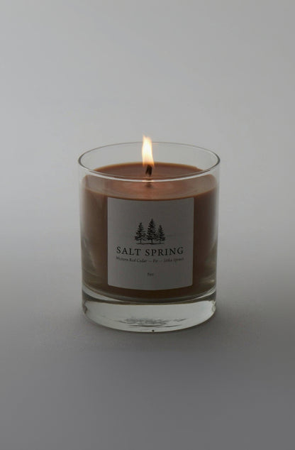 Candle in a glass jar with a label on a gray background