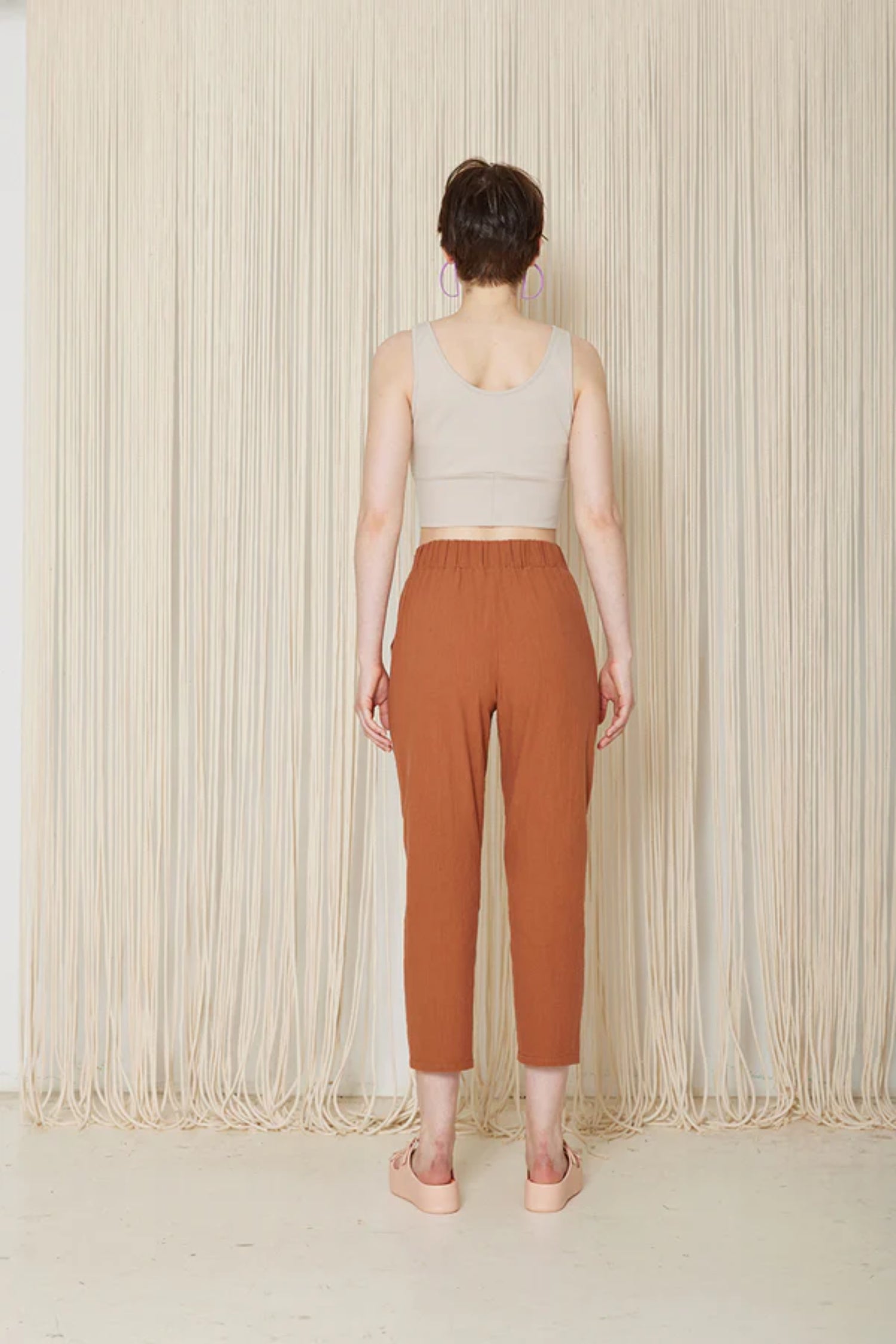 Hosta Pants by Cokluch, Sienna, back view, elastic waist, sewn-in belt  held in place with loops and buttons, tapered ankle-length legs, eco-fabric, cotton, OEKO-TEX certified, sizes XS to XL, made in Montreal 