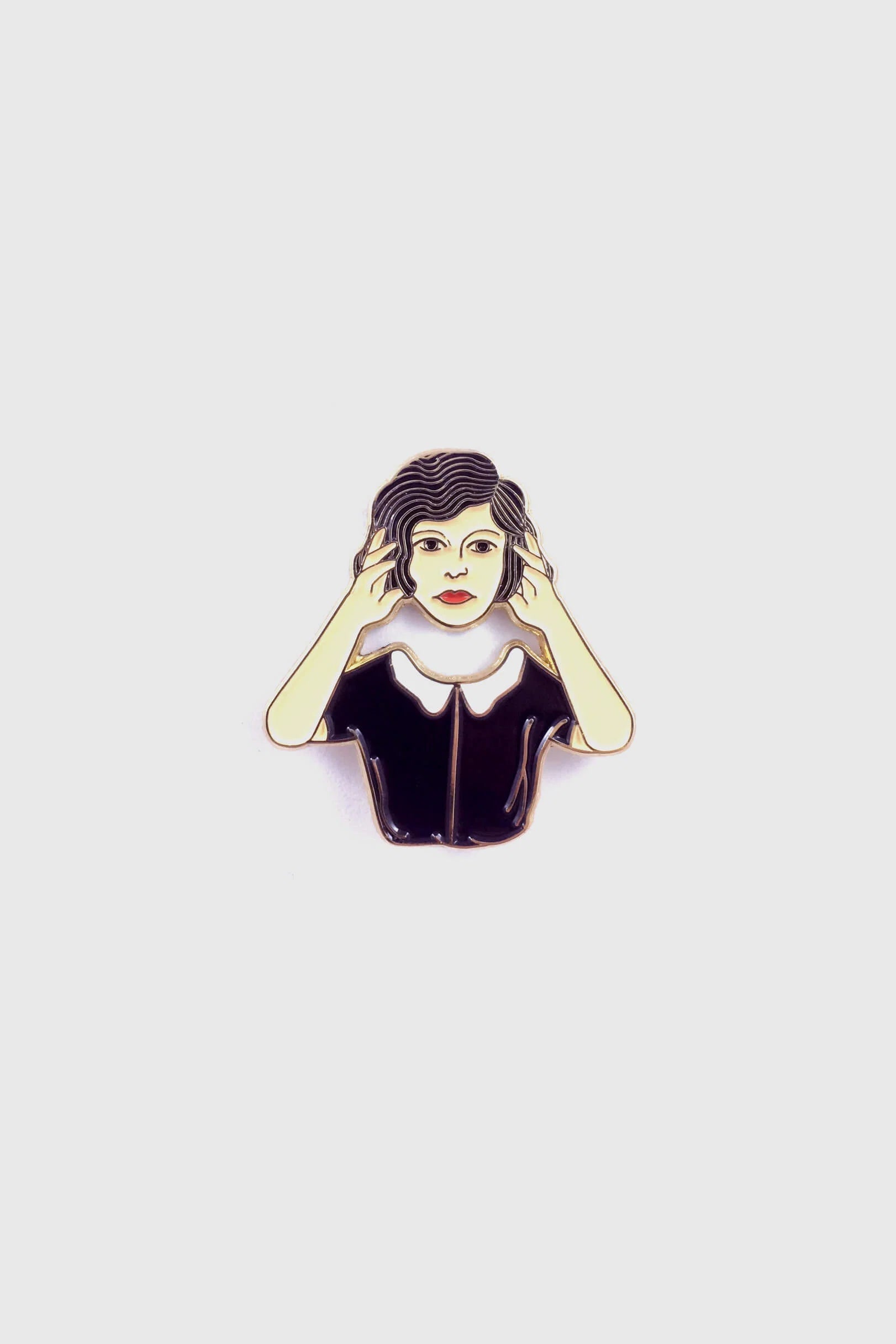 The Floating Head Pin by Badaboöm Studio, an enamel pin showing a woman lifting her head over her shoulders, is shown against a white background. 