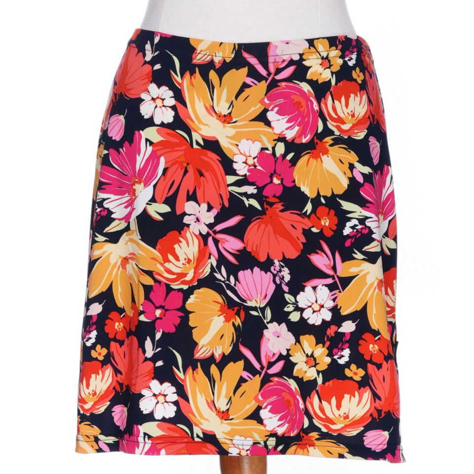 The Cocktail Skort by Rien ne se Perd in Red/Orange floral print, an elastic waist miniskirt with built-in matching bike shorts, is shown on a mannequin against a white background.