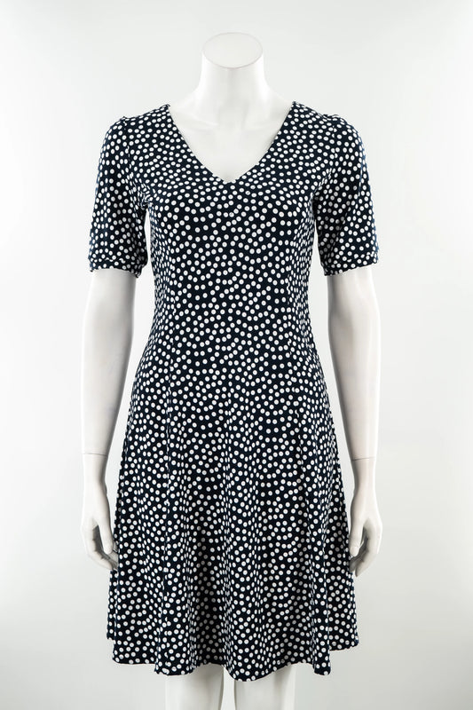 The Navy Polka Dot Dresss by Karkass is shown on against a white background. It has a v-neck, short sleeves, princess seams, and an above the knee hem. 