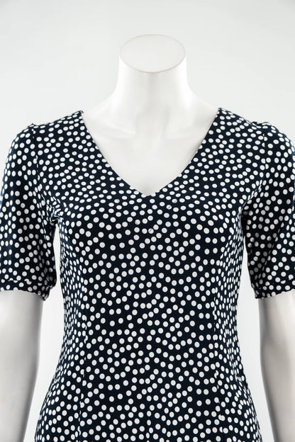The Navy Polka Dot Dresss by Karkass is shown on against a white background. It has a v-neck, short sleeves, princess seams, and an above the knee hem. 