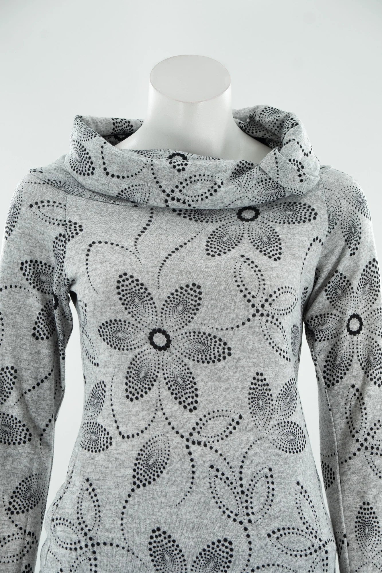A close up of the Teddy Pearl Sweater by Karkass in Grey and Black, a cowl neck sweater with a floral pattern in black dots, is shown on a mannequin with jeans against a white background. 
