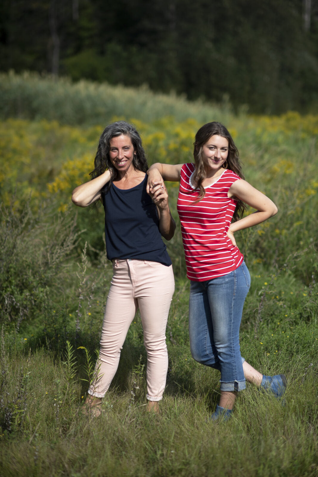 Two women wearing the Sol Top by Marie C, one in Navy and one in Red Stripe, with a scoop neck and cap sleeves. They are standing in a field. 