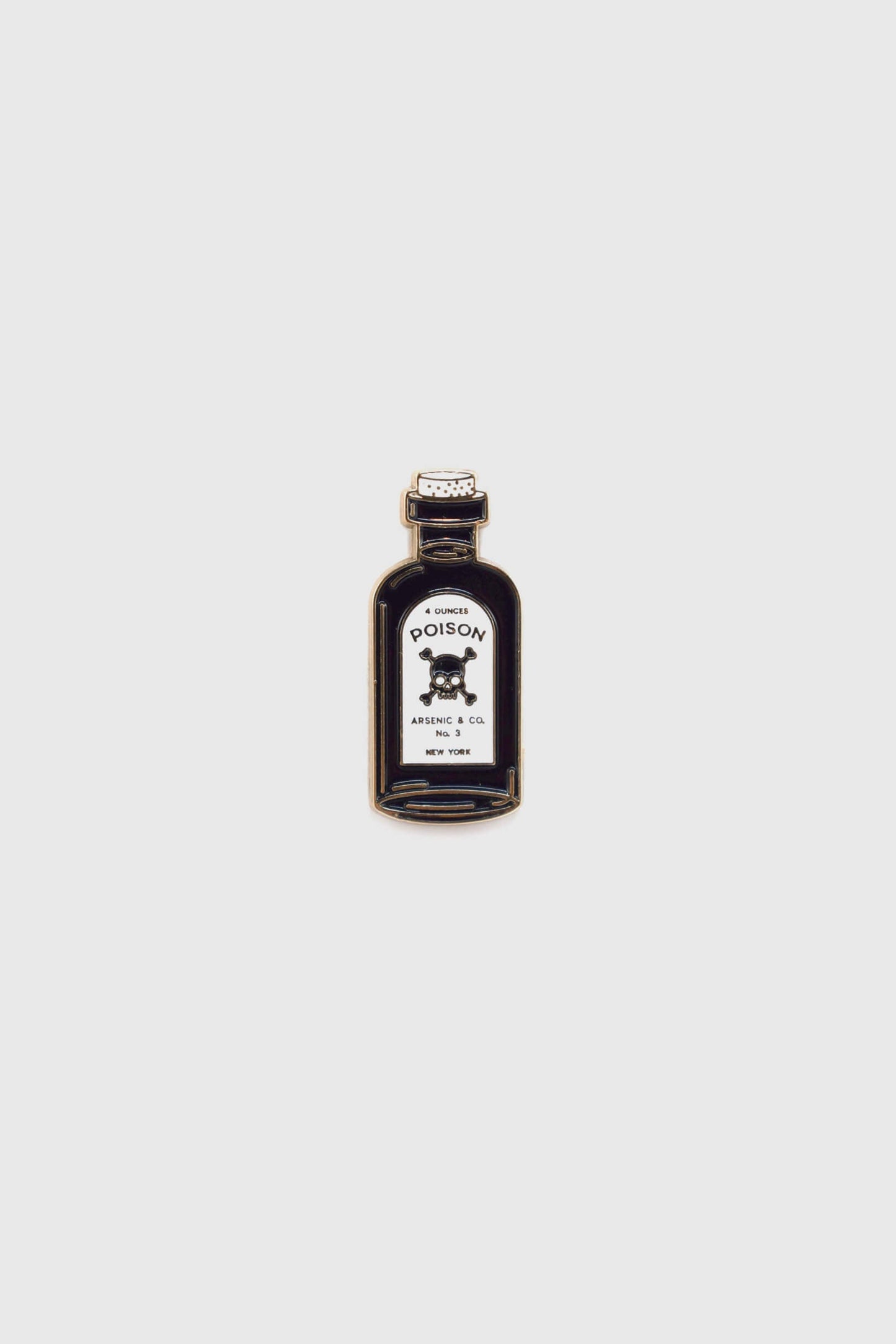 The Poison Pin by Badaboöm Studio, featuring a tiny bottle of poison, is shown against a white background. 