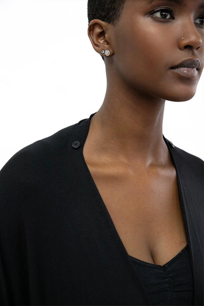 Close up shoulder detail of a woman wearing the Endless Bamboo Multi-wrap top by Stacey Martin Lifestyle in Black, a top that can be wrapped and fastened by the shoulder buttons in many different ways.