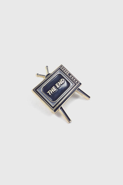 Badaboöm Studio's retro television-shaped enamel pin with 'THE END' lettering on the screen, set against a plain light grey background.
