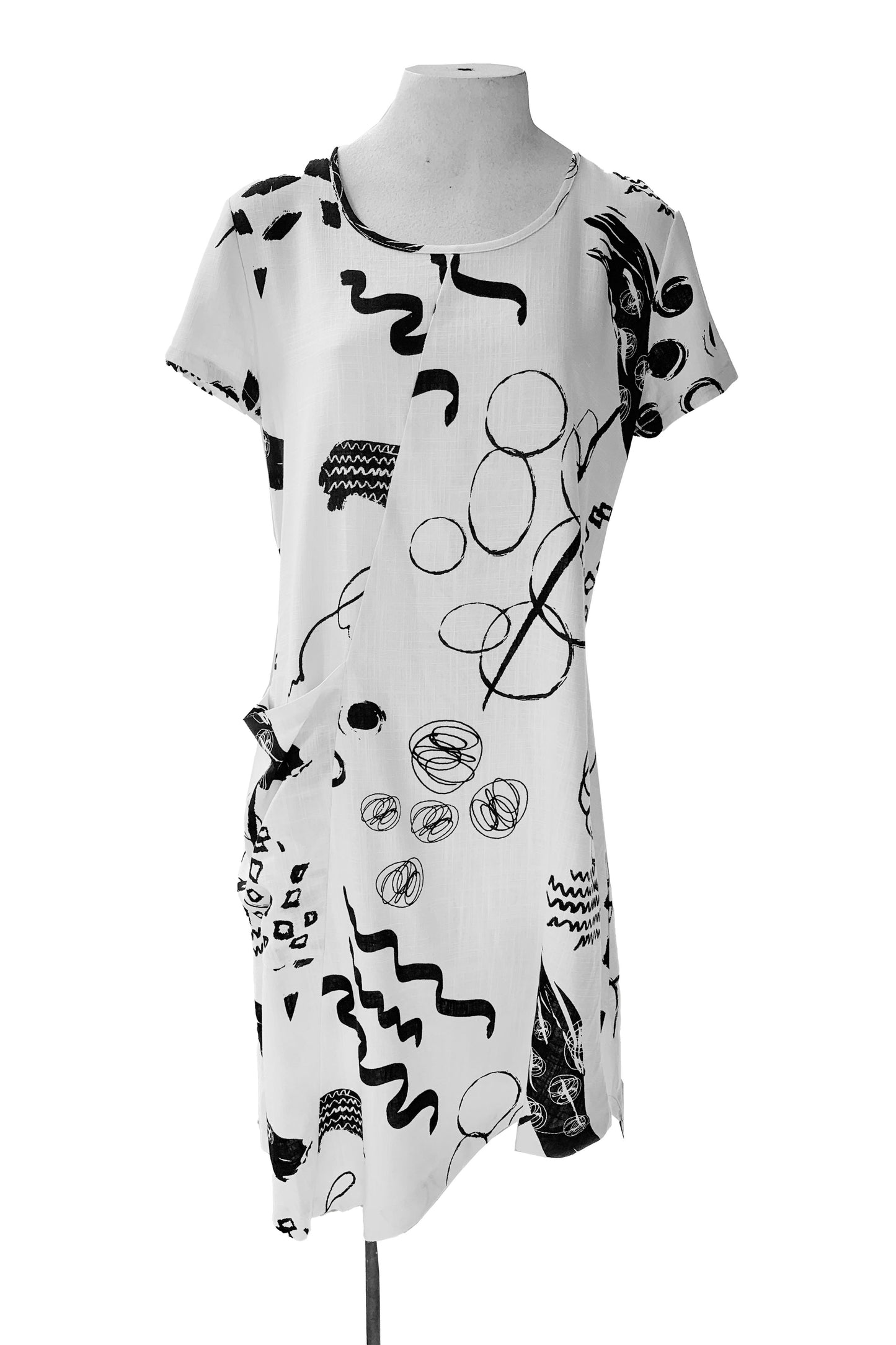 Mika Dress by Compli K, White with black abstract designs, round neck, short sleeves, diagonal seams, asymmetrical hem, one pouch pocket, eco-fabric, rayon and linen, sizes XS to XXL, made in Montreal